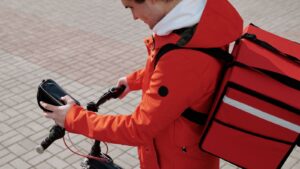 Food delivery cyclist checking a smartphone while working
