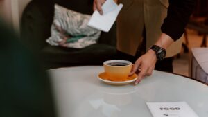 Barista serving coffee in a busy cafe