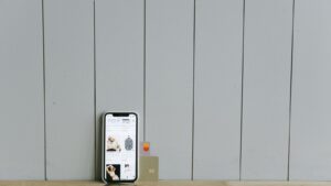 A smartphone displaying an ecommerce site with a credit card, set on a wooden surface, depicting online shopping.