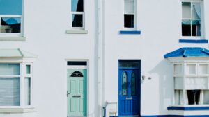 A modern exterior featuring a contrast of blue and green doors on a white building facade.