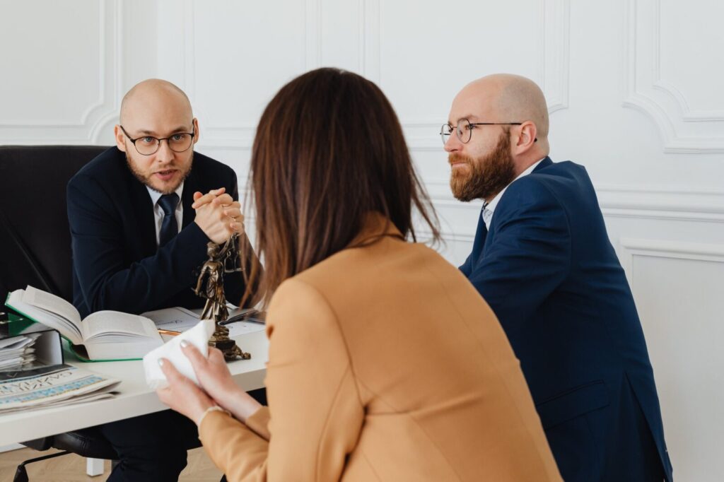 Client meeting two lawyers across a desk