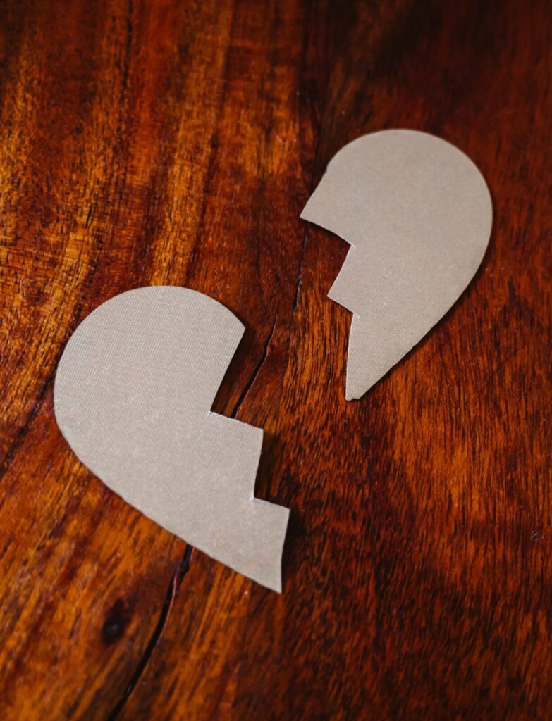 Paper heart torn in two on a wooden table