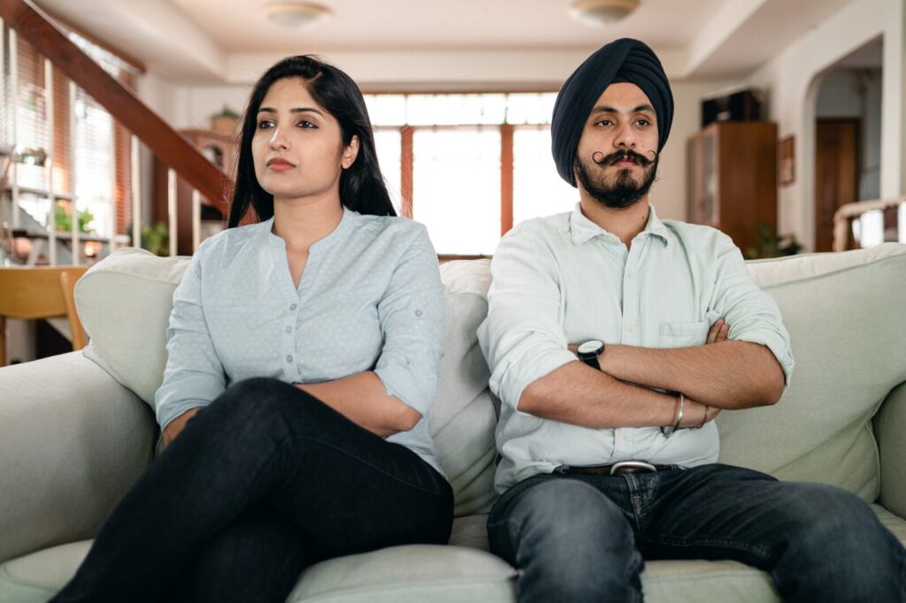 Couple sitting with arms folded on a sofa
